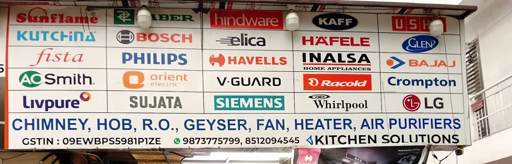The shop board above the door, printed with brand names and the line chimney, hob, R.O., geyser, fan, heater, air purifiers