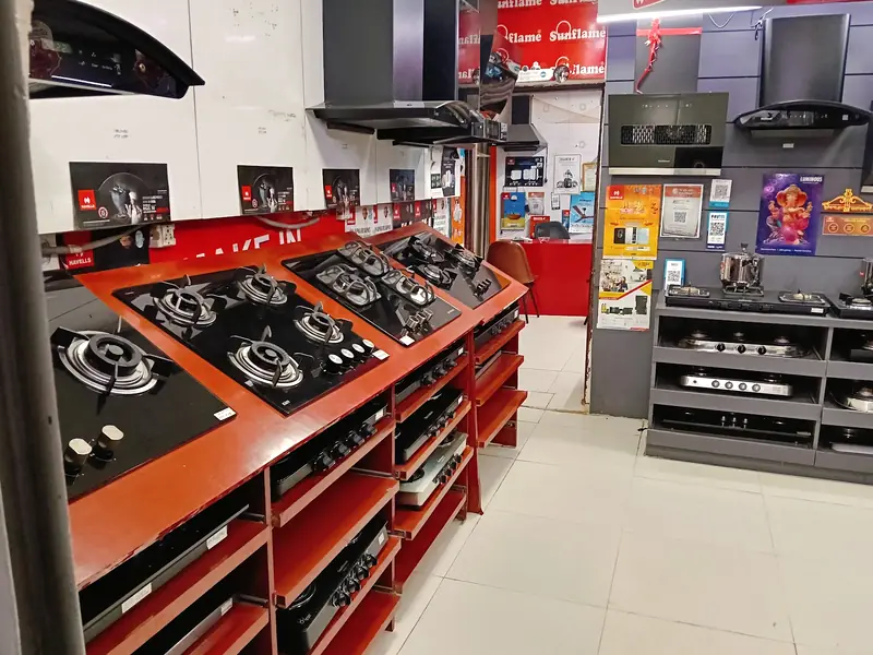 Rows of gas hobs on display racks inside the shop, with chimneys mounted on the wall behind